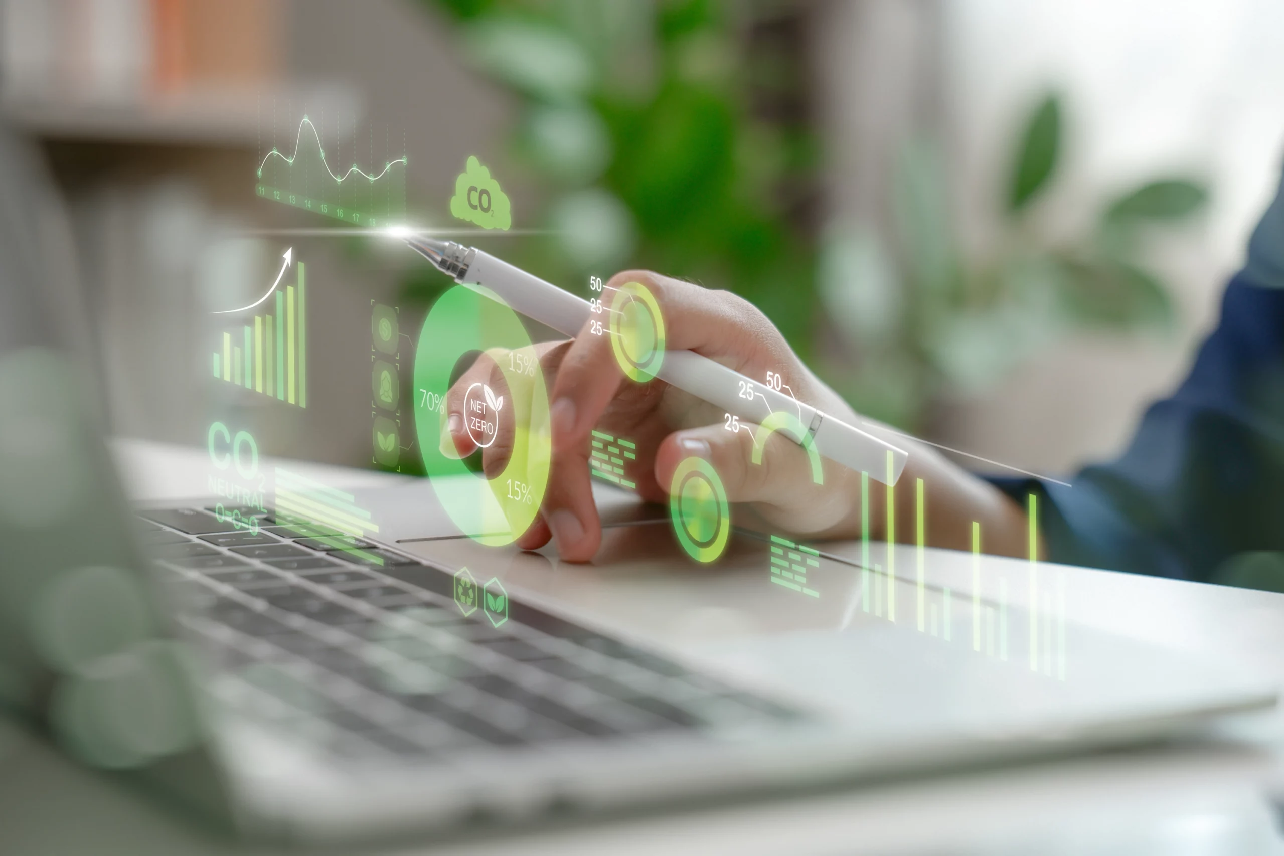 Hand zeigt auf holografische Nachhaltigkeits- und CO₂-Analysen, die über einem Laptop eingeblendet sind; das Bild symbolisiert umweltbewusste Produktion, klimafreundliche Prozesse und nachhaltige Drucklösungen.