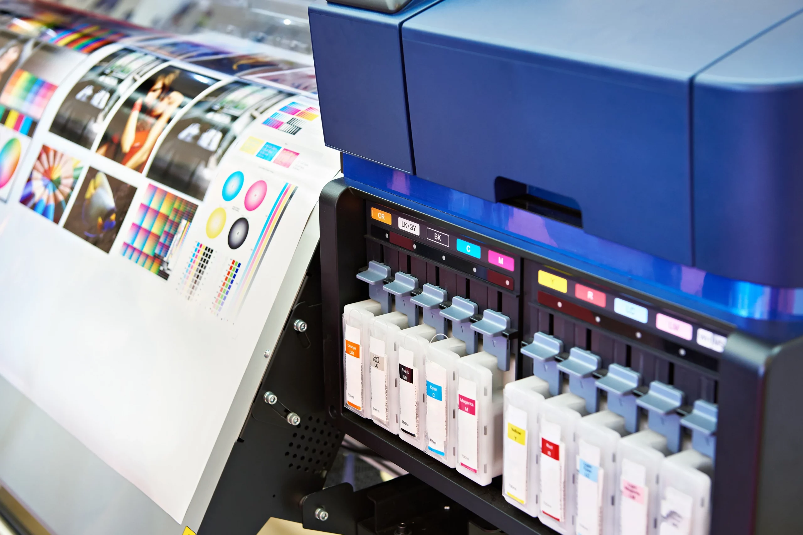 Digitaldruckmaschine mit Farbkartuschen und gedruckten Farbmustern; moderne Drucktechnik für individuelle, flexible und hochwertige Digitaldruck-Lösungen wie Flyer, Broschüren oder personalisierte Printmedien.